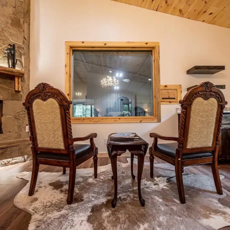 A luxury suite with large windows overlooking a giraffe barn, capturing the unique wildlife experience at Oak Meadow Ranh RV in Valley View, TX.