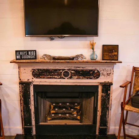 A cozy, wooden cabin nestled in a scenic setting with the sun setting behind it, emphasizing the rustic charm and peaceful atmosphere at Oak Meadow Ranch RV in Valley View, TX.