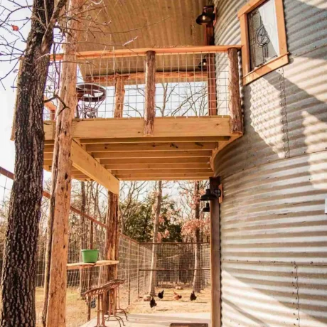 A cozy, wooden cabin nestled in a scenic setting with the sun setting behind it, emphasizing the rustic charm and peaceful atmosphere at Oak Meadow Ranch RV in Valley View, TX.