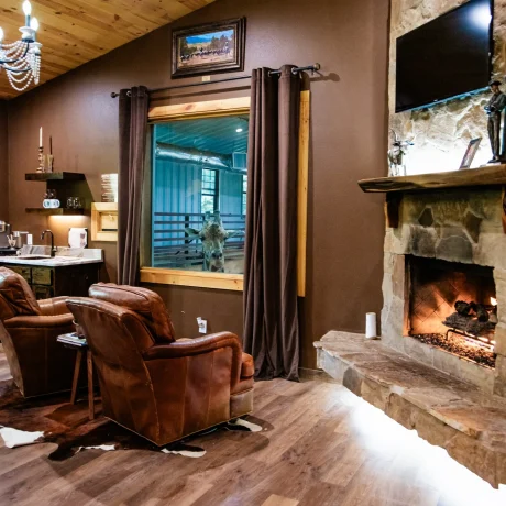 A luxury suite with large windows overlooking a giraffe barn, capturing the unique wildlife experience at Oak Meadow Ranh RV in Valley View, TX.