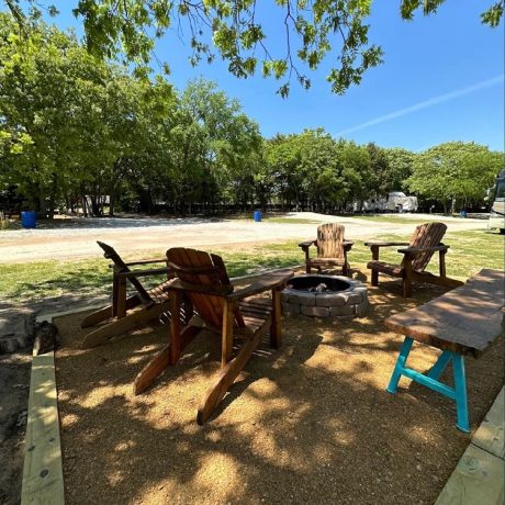 Picturesque RV sites nestled among shady oak trees with tranquil, spacious surroundings, fire pits, and picnic tables at Oak Meadow Ranch in Valley View, TX.