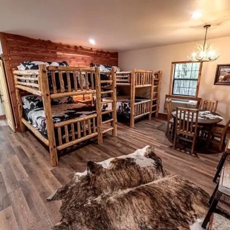 A luxury suite with large windows overlooking a giraffe barn, capturing the unique wildlife experience at Oak Meadow Ranh RV in Valley View, TX.